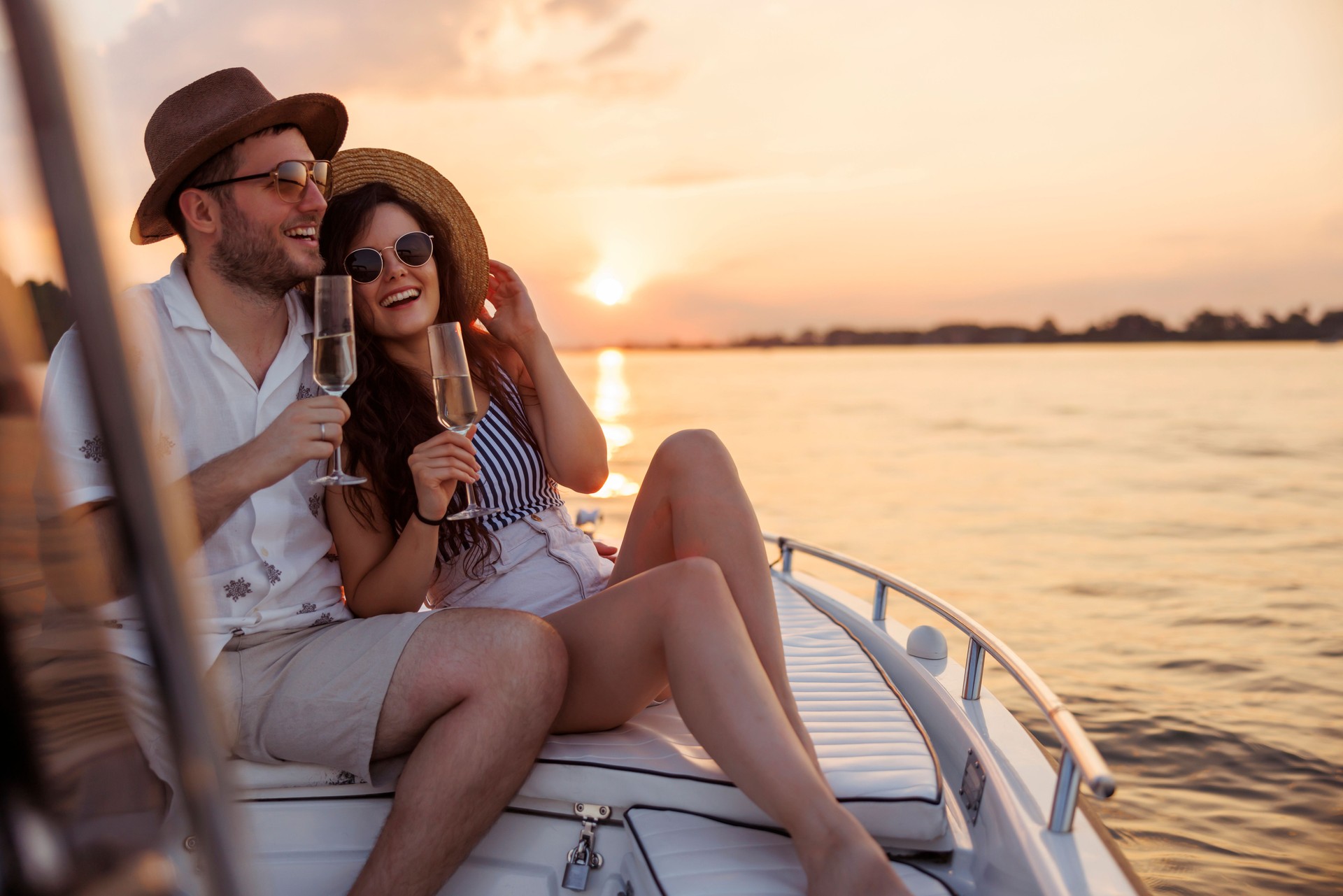 Coppia che brinda con champagne su uno yacht al tramonto